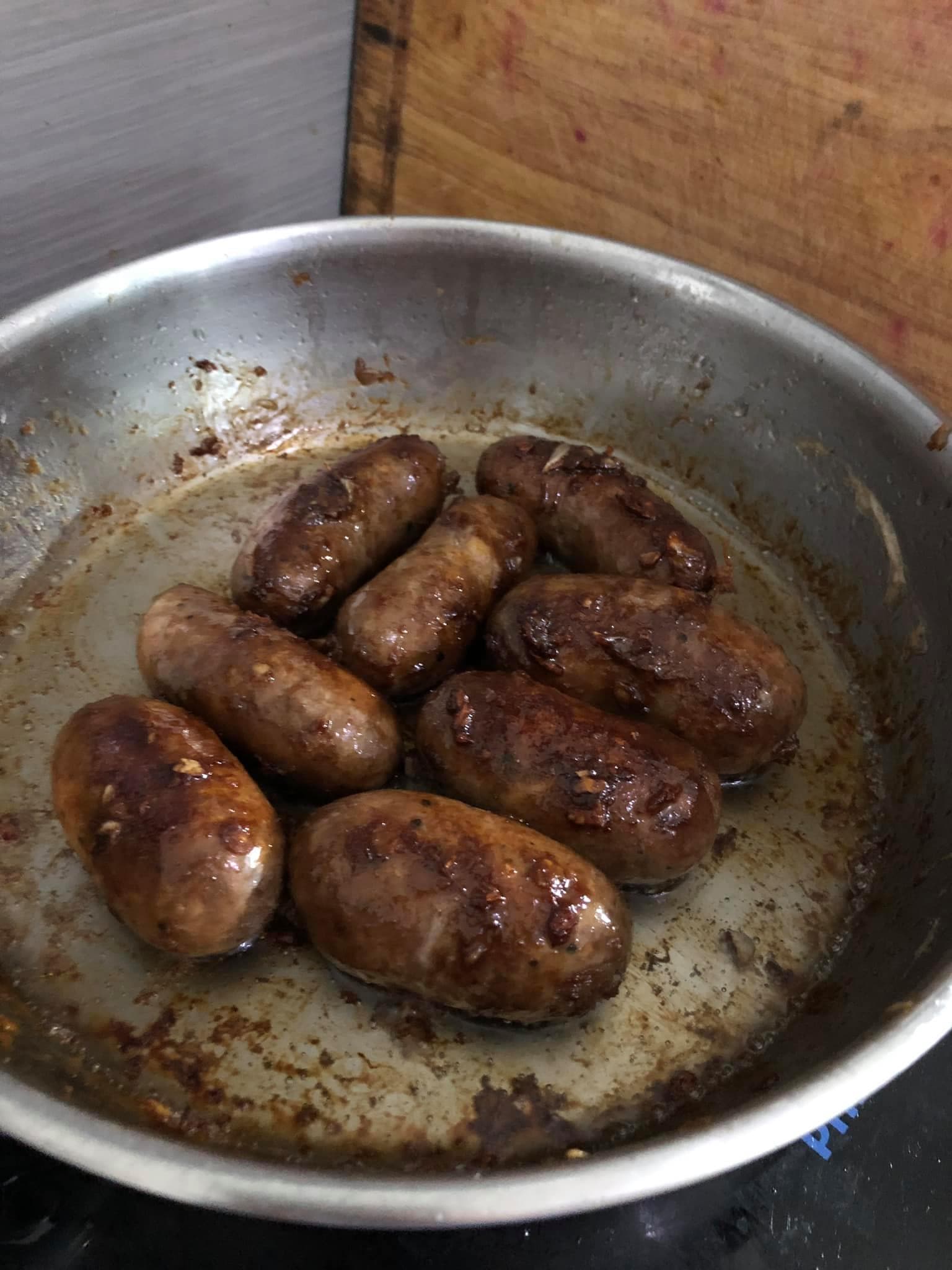 Ilocos longganisa frying in a pan at home